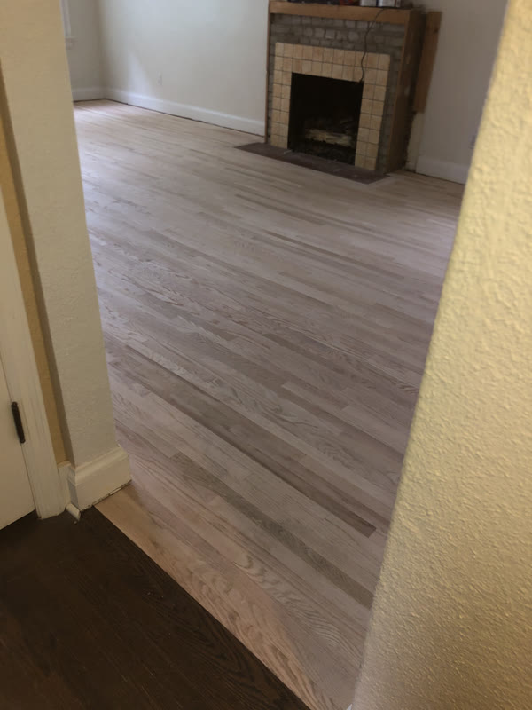 Living room with a fresh light hardwood floor and tiled fireplace